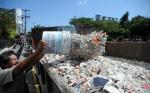 Un trabajador hecha los restos rotos de la obra de arte a un contenedor de&nbsp;basura.